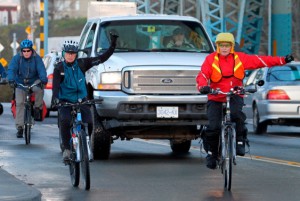 Cyclists signal while crossing the Johnson Street Bridge. Hand signals are useful for all users of the road, including drivers and pedestrians, by increasing fellow road users' knowledge of your intentions. Photograph by: ADRIAN LAM, Times Colonist
